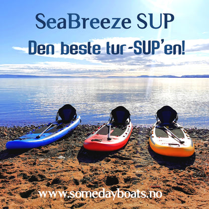 SeaBreeze Tur-SUP 2021 modell vist i blå, rød og gul farge på stranden med sjøen og blå himmel i bakgrunn. Tekst på bilde sier " SeaBreeze SUP. Den beste tur-SUPen".